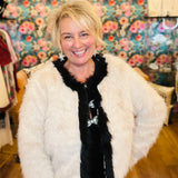 Cream faux fur jacket with black contrast trim details